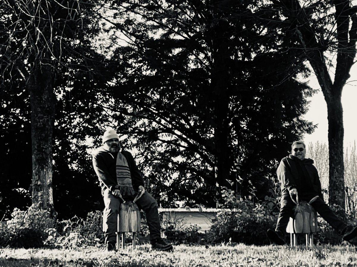 Milos (à gauche) et Rico (à droite), assis sur des animaux à ressort dans un jardin, photographie en noir et blanc